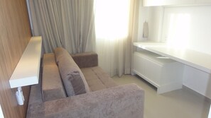 Een moderne, goed verlichte kamer met een bank, een klein tafeltje en een inbouwbank.
