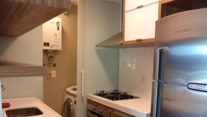 Una cocina moderna con un refrigerador de acero inoxidable, armarios de madera y un horno empotrado.