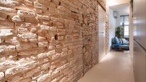 A hallway with exposed brick walls and a modern interior. - Officine Cavour Apartments (Padova)