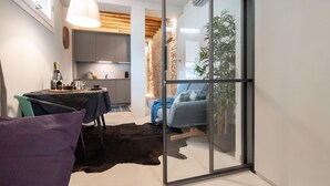 A modern living space with a dining area, a sofa, and a glass partition. - Officine Cavour Apartments (Padova)