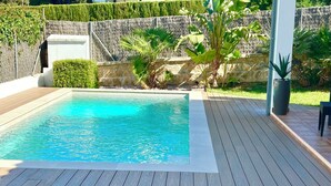 A rectangular swimming pool with clear blue water, surrounded by a wooden deck. - Vacation Villa with Pool and Breathtaking Ocean Views, Last-Minute Deal for September 2026 (Alcudia)