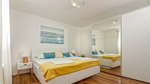 A modern bedroom with a large bed, a bedside table, a mirror, and a painting on the wall. - Stone house with  pool (Donje Sitno)