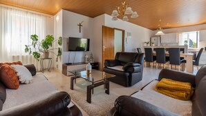 A modern living room with a glass coffee table, leather sofas, a TV, and a dining area with chairs and a table. - Stone house with  pool (Donje Sitno)