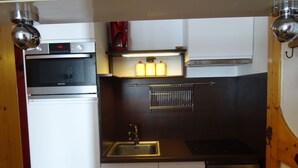 A compact kitchen with a built-in oven, a sink, and a stove. - Comfortable 2-room apartment in Arc 2000 for 6 people (Les Arcs 2000)