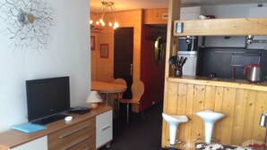 A compact room with a TV, a desk, a chair, a small dining table, and a kitchenette area. - Comfortable 2-room apartment in Arc 2000 for 6 people (Les Arcs 2000)