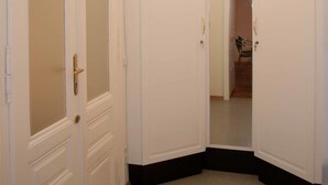A hallway with white doors, a light fixture on the ceiling, and a glimpse of a chair in the background. - Raisa Apartments (Pressbaum)
