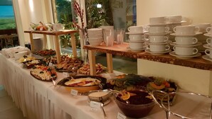 A buffet setup with various food items and serving utensils. - Land Gut Hotel Weisser Schwan (Zossen)