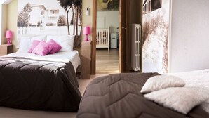 Un dormitorio con dos camas, un radiador y una puerta que da a otra habitación.