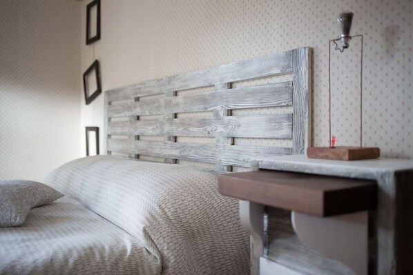 A bedroom with a bed, a headboard, and a wall-mounted lamp. - MeraVilla B&B (Ascoli Piceno)