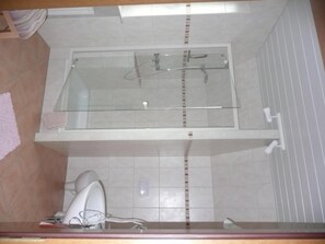 A bathroom with a glass-enclosed shower, a toilet, and a mirror. - Pension zum Fernblick (Willingen)