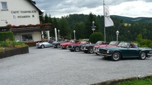 A row of vintage cars parked in front of a building labeled "CAFE FERNBLICK PENSION". - Pension zum Fernblick (Willingen)