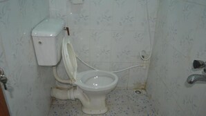 Un baño pequeño y sencillo con inodoro, lavamanos y ducha.