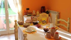 Una mesa de desayuno con diferentes alimentos, una cafetera y un radiador.