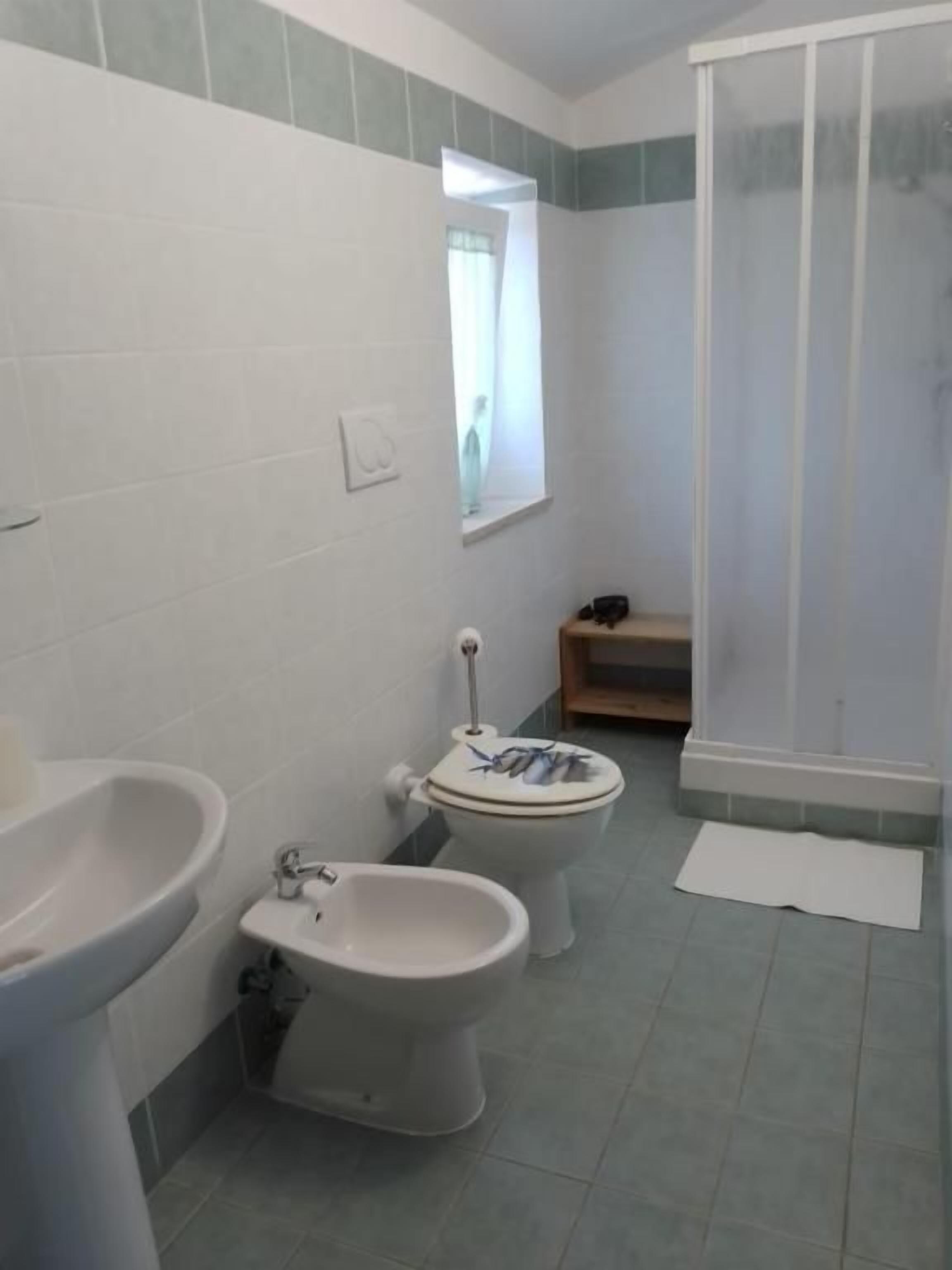 A bathroom with a toilet, bidet, and sink.