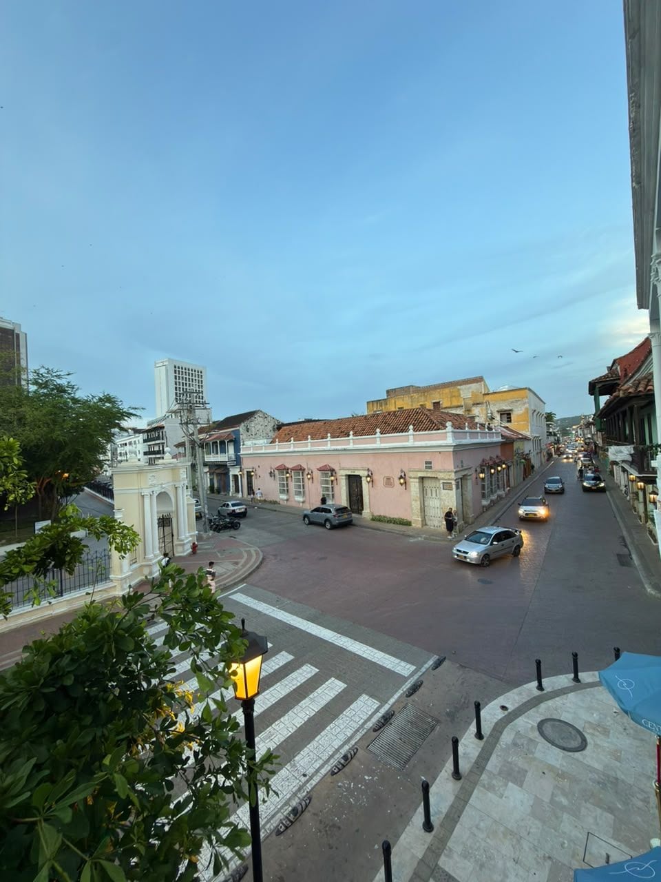 A street view with buildings, a pedestrian crossing, and vehicles.