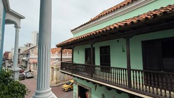 A building with a balcony, a street view, and a clear sky.