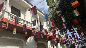 A building with balconies adorned with various international flags. - Casa 1811 (Cartagena)