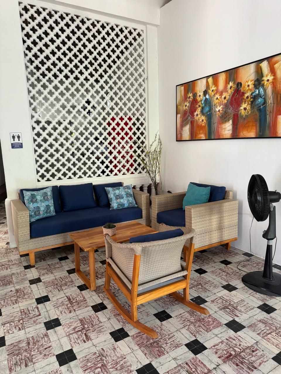 Ein Zimmer mit einer Sofagarnitur, einem Couchtisch und einem Ventilator.