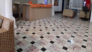 A lobby with a reception desk, a check-in counter, a large pillar, and a tiled floor. - Casa 1811 (Cartagena)