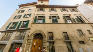A historic building with a central arched entrance, multiple windows with shutters, and a sign indicating a restaurant. - Efeso (Florence)