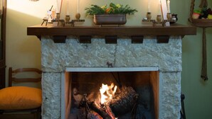 A fireplace with a large antler mounted above it, surrounded by candles and decorative items. - Poggio Eco B&B (Ascoli Piceno)