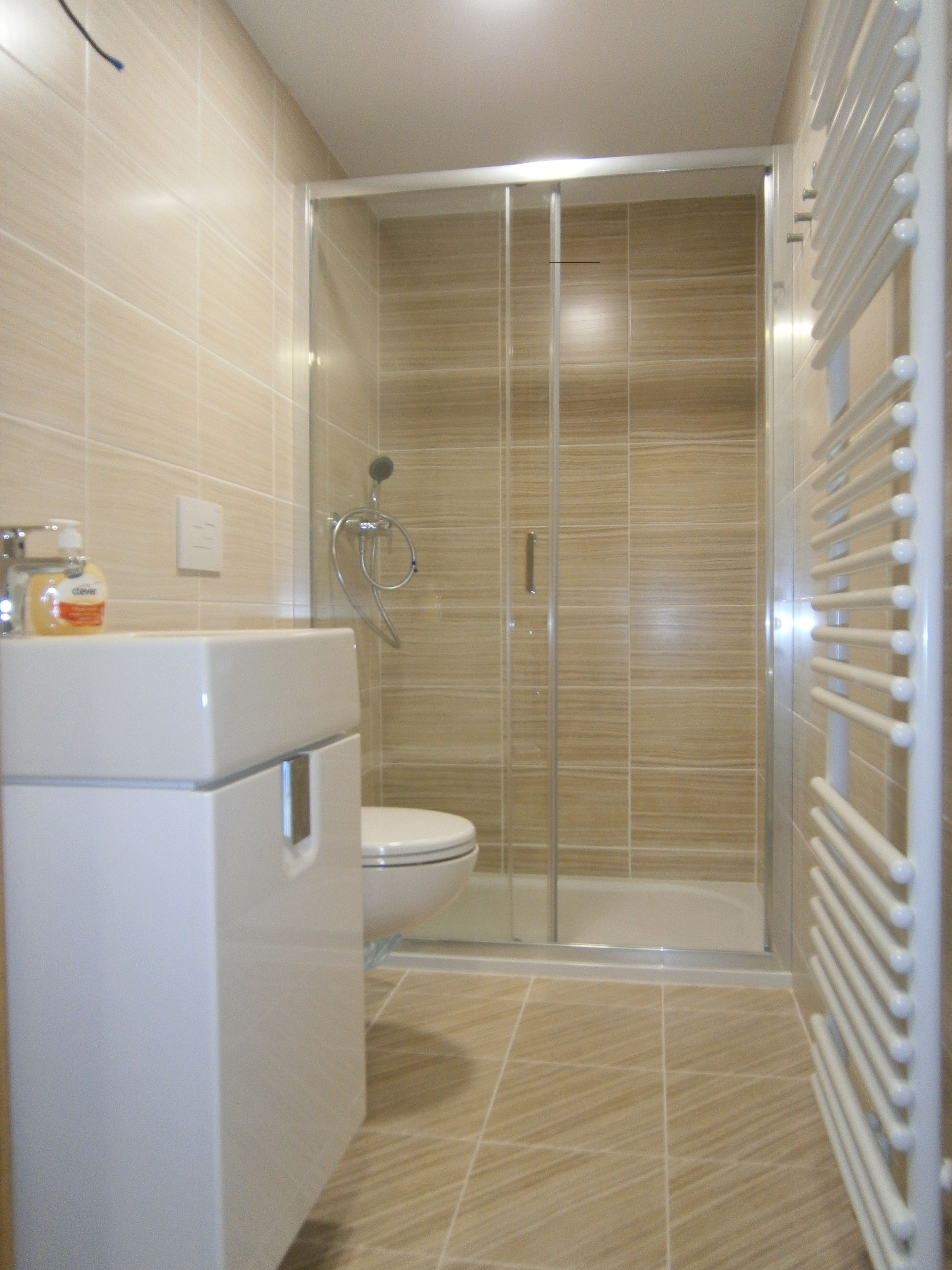 A bathroom with a shower, toilet, and a built-in sink.