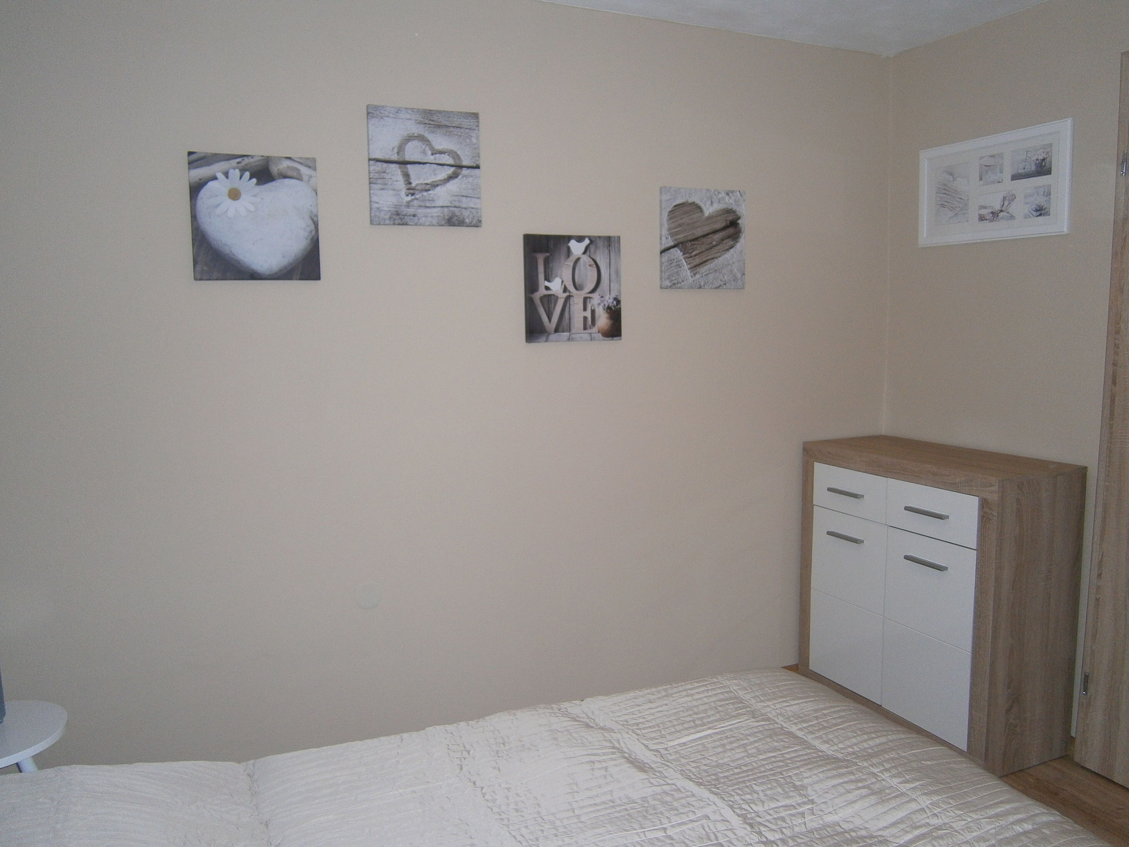 Un dormitori amb llit, una petarrera i decoració a la pared.