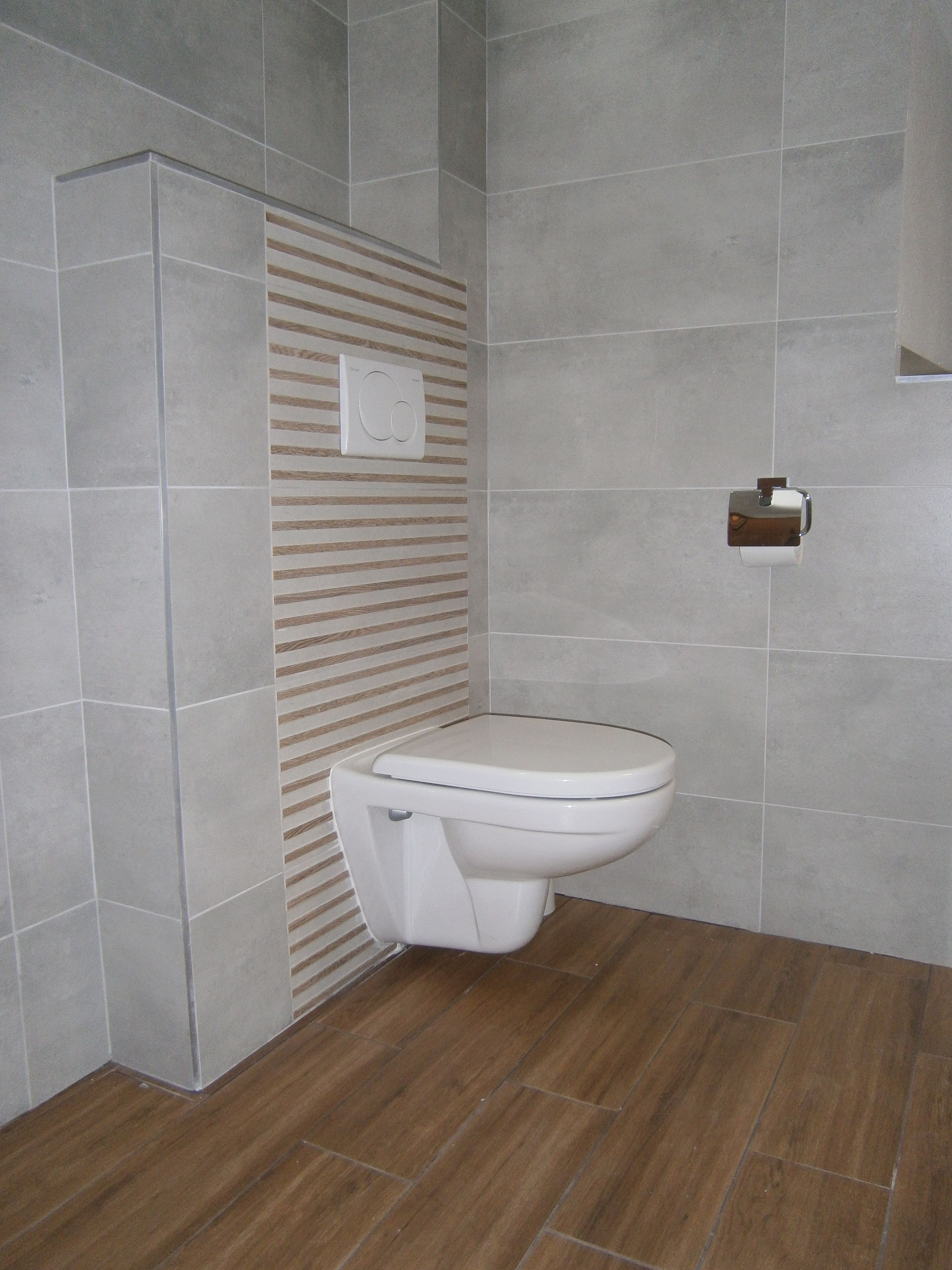 Ein modernes Badezimmer mit Toilette, wandmontiertem Bidet und einem Händetrockner.