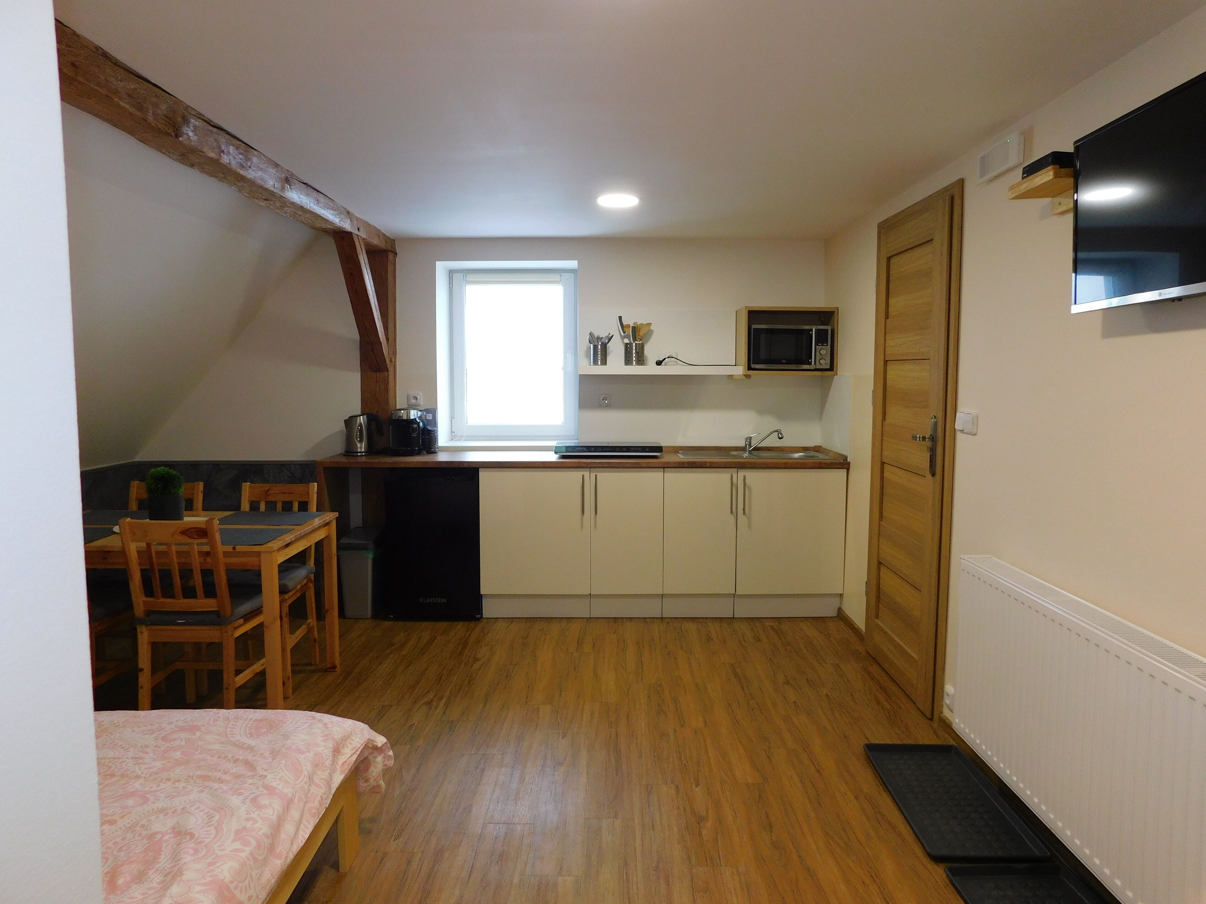 A compact kitchen with wooden cabinets, a microwave, and a sink.