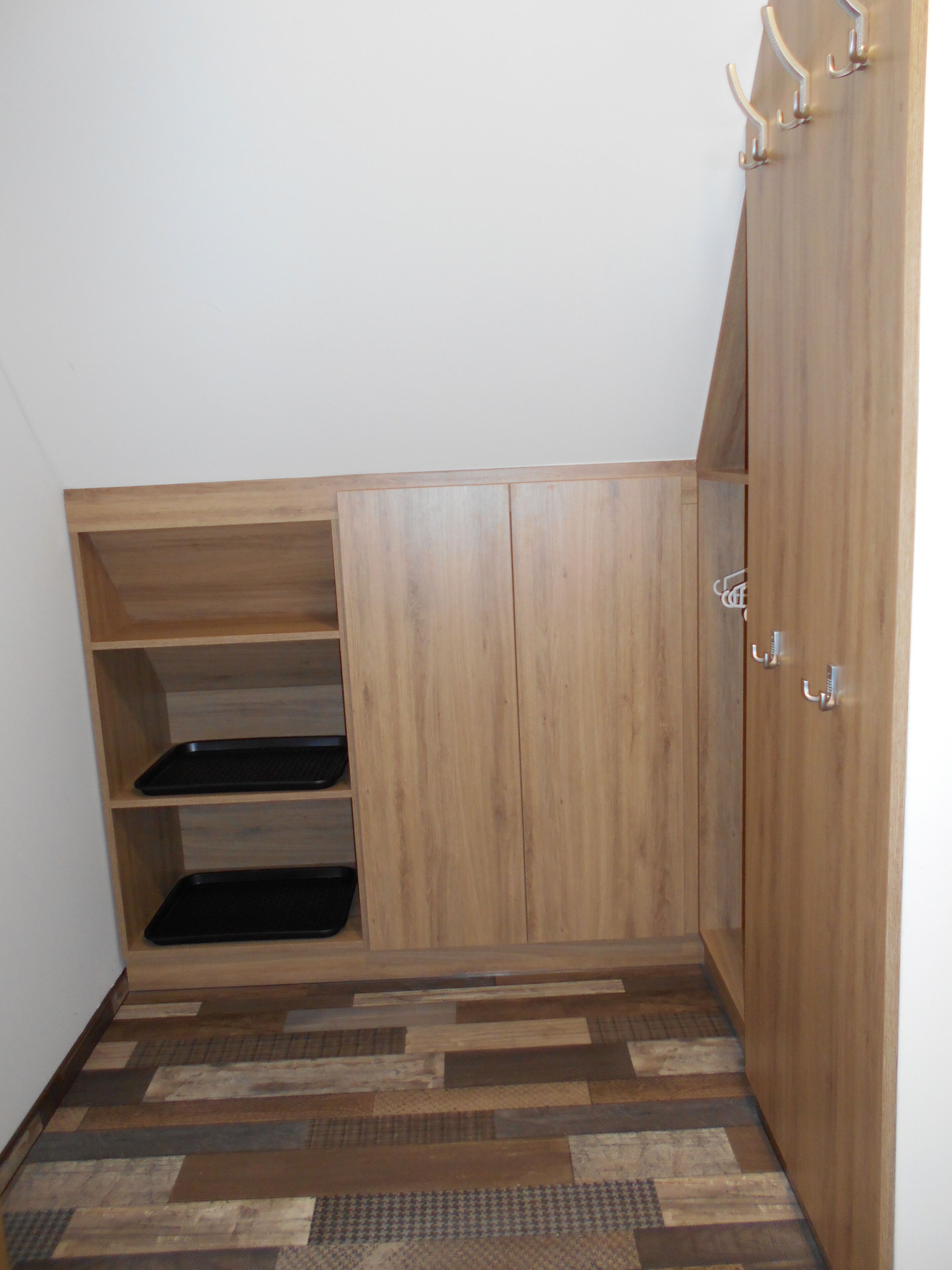 Une pièce d’angle avec des meubles de rangement en bois et une bibliothèque intégrée.