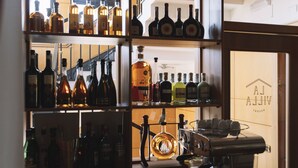 A bar area with shelves of liquor bottles and a coffee machine. - La Villa Resort Charme & Relax (Pignola)