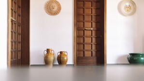 A room with a wooden door, two ceramic vases, and a green bowl on the floor. - La Villa Resort Charme & Relax (Pignola)