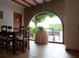 Un comedor con un arco de piedra que da a un patio al aire libre.