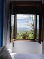 Un dormitorio con ventana que da a un paisaje.