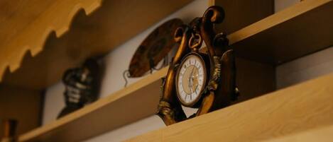 A wooden shelf with a clock and a decorative item.