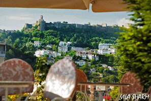 A view of a hillside with buildings and a castle-like structure. - Sharm Hotel (Gjirokastër)