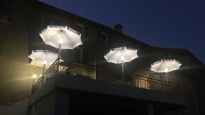 A building with three outdoor umbrellas labeled "Henniez" on a balcony. - Albergo Ristorante Belcantone (Novaggio)