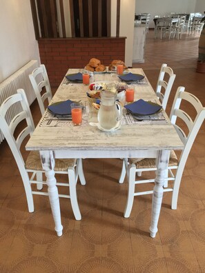 A dining table set with breakfast items, including croissants, juice, and a pitcher.
