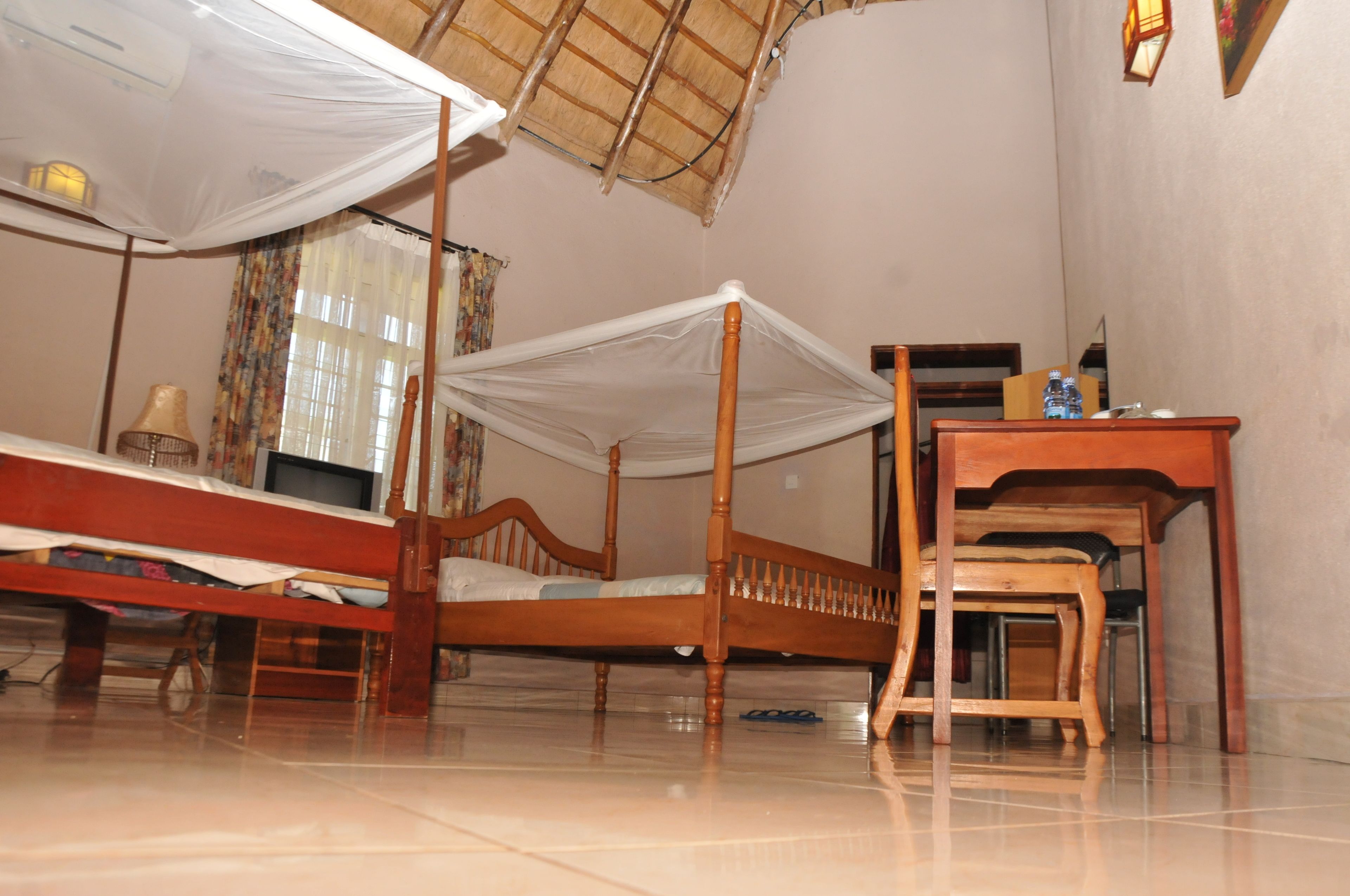 A room with a wooden bed, a desk, and a chair.
