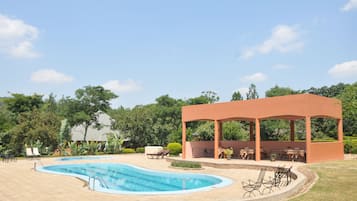 Una piscina al aire libre de temporada, tumbonas