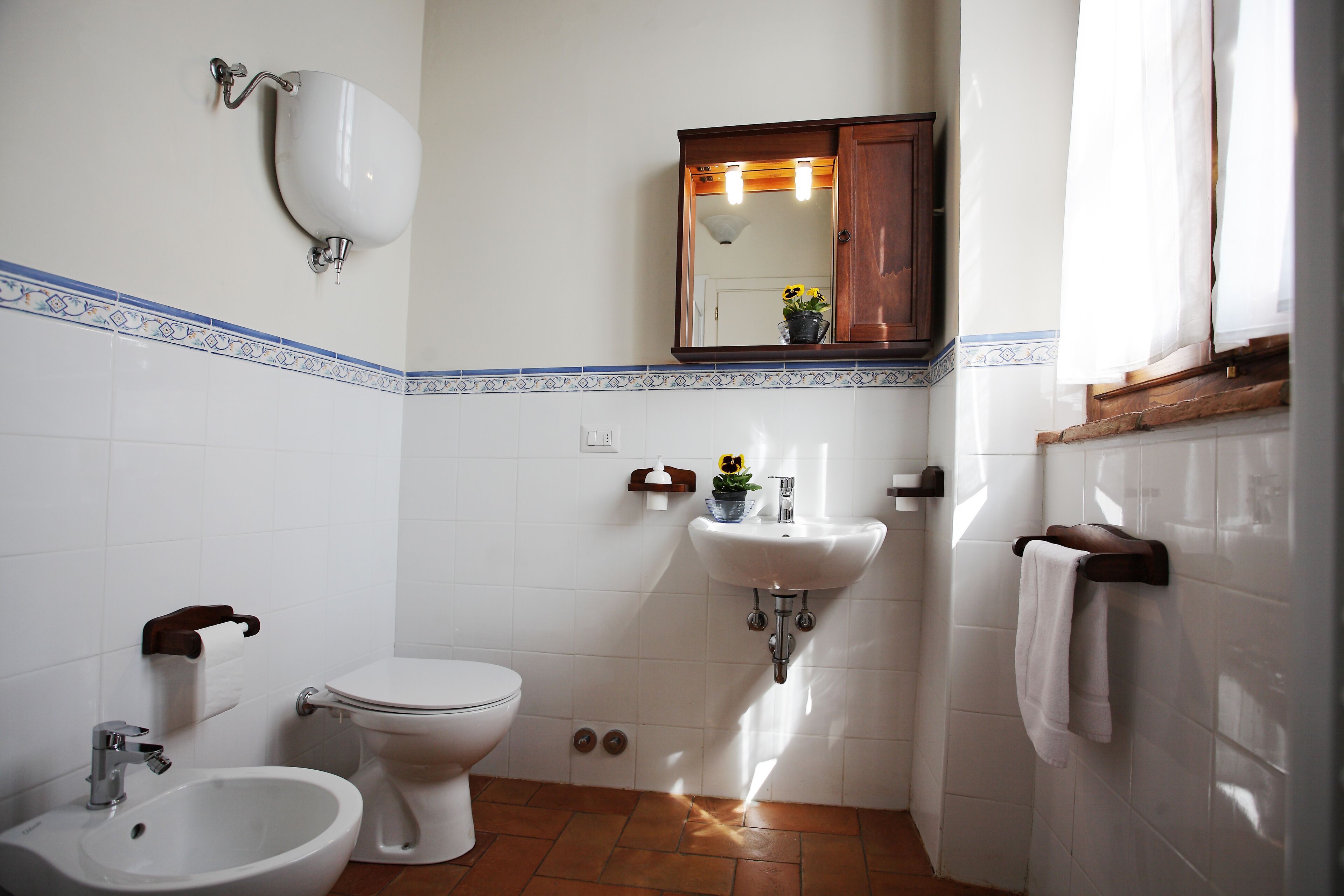 Ein Badezimmer mit Toilette, Bidet, Waschbecken und Spiegel.