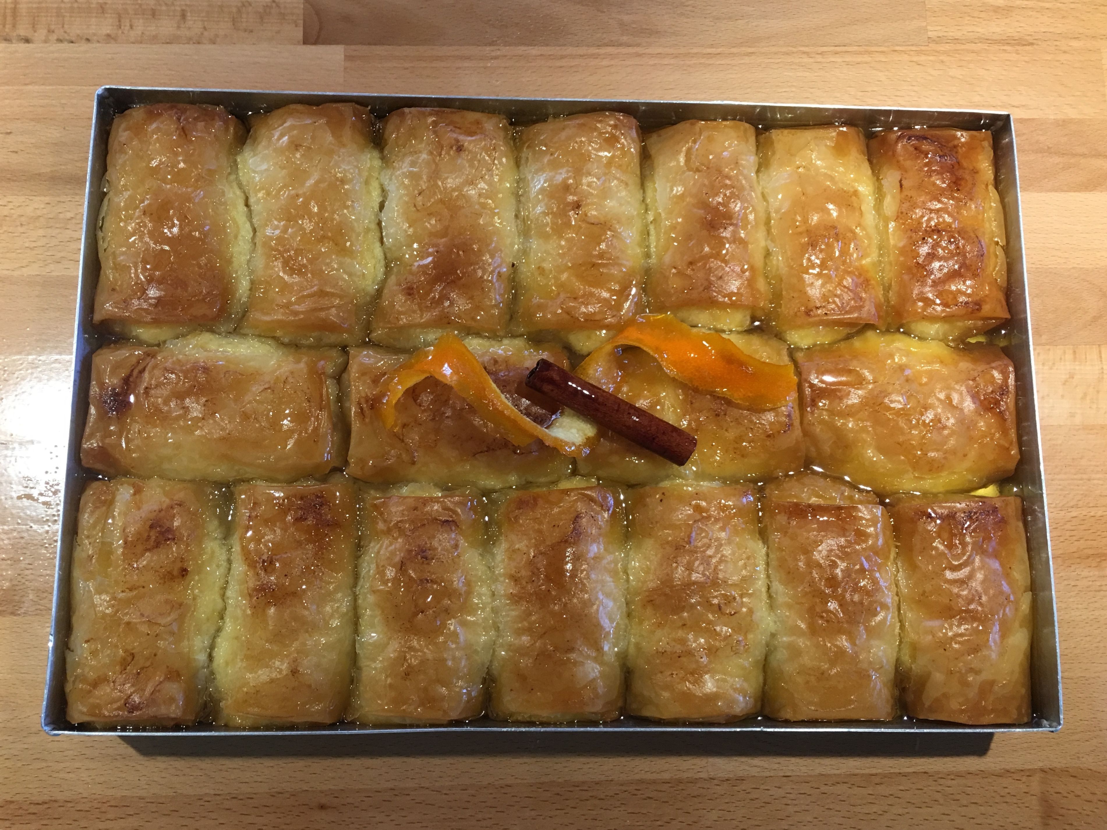 A tray of baked pastries arranged in a rectangular metal dish.