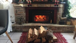 Una chimenea con fuego, una silla y una alfombra.
