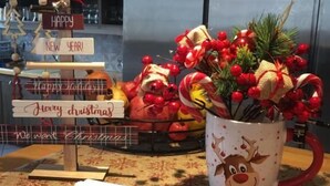 Una cocina decorada para las fiestas, con un árbol de Navidad, una taza con diseño de reno y adornos navideños.