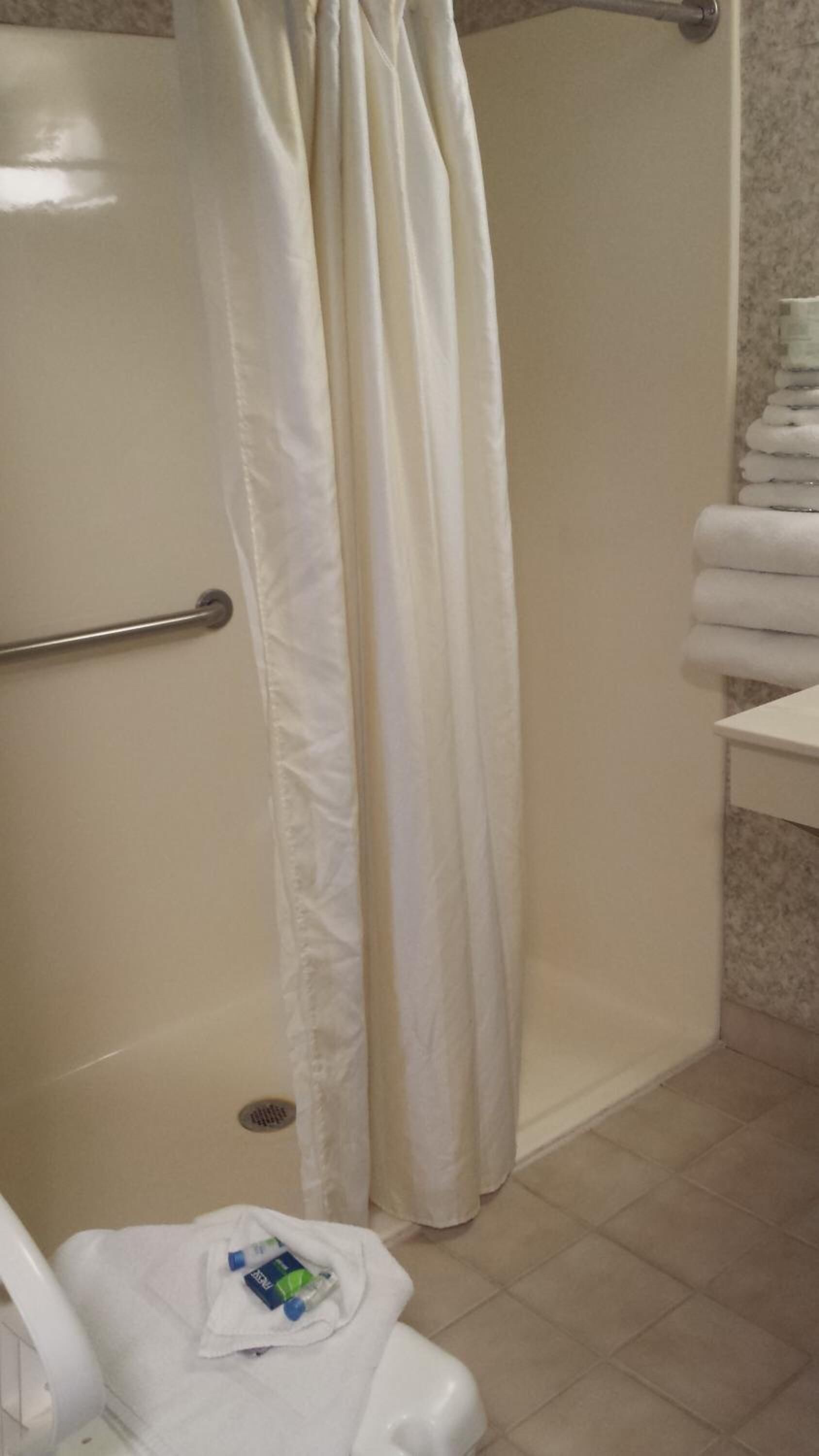 A bathroom with a shower, a toilet, and a sink.