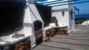 A stone and white building with a built-in grill and a stone fireplace. - Villa Juan (Frontera)