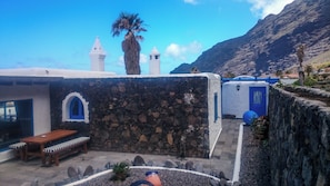 Un edificio de paredes de piedra con un banco de madera y una puerta.