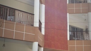 A multi-story building with balconies, tiled floors, and a central column. - Hotel Le Littoral des Almadies (Dakar)