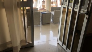A balcony with wicker furniture and a tiled floor. - Hotel Le Littoral des Almadies (Dakar)