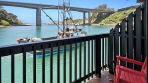 A bridge over water, a boat, and a red chair on a dock. - Anchor Lodge  (Fort Bragg)